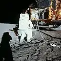Alan Bean extrait le deuxième paquet du compartiment SEQ. Cela est effectué en partie en utilisant un palan et un système de poulies visible sur la photo. Pour Apollo 17, le système est jugé trop complexe et supprimé. Pour Apollo 11, Buzz Aldrin décide pour économiser du temps de ne pas utiliser le système.