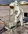 Jim Lovell s'entrainant pour la mission Apollo 13. Il installe une maquette du poste central. Le poste se déploie grâce à un système de ressorts.