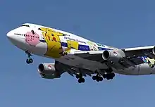 Photo d'un avion All Nippon Airway, en vol, décoré de différents Pokémon.