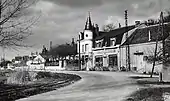 Photographie en noir et blanc d'une route longeant une ancienne commune.