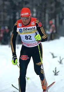 Fondeur de pfac, avec bonnet et lunettes, en train de skier.
