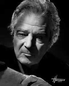 portrait photographique en noir et blanc d'un homme grisonnant, travaillé en clair-obscur avec fond noir.