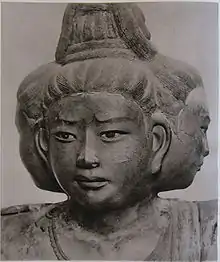 Portrait d'une sculpture à trois faces pointant vers l'avant et des deux côtés.