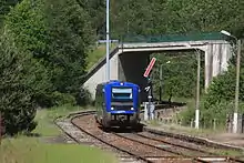 Un TER entre en gare, vu au droit d'un sémaphore mécanique.