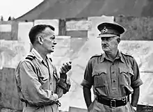 Photographie en noir et blanc de deux hommes militaires en pleine discussion.