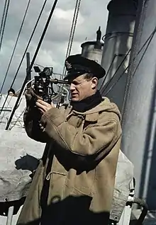 Un officier de la Royal Navy utilisant un sextant, à bord d’un destroyer en mission de protection d’un convoi en 1942.