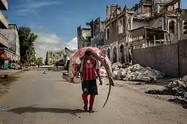 Homme transportant un requin-marteau halicorne à Mogadiscio (Somalie).