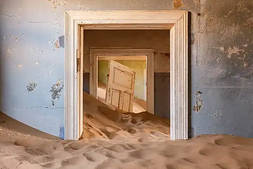 Une maison envahie par le sable.