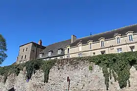 L'abbaye vue d'en-dessous les remparts. À gauche, la tour de la porte antique Saint-Andoche.