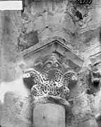 Photographie en noir et blanc d'un chapiteau orné d'un décor de feuilles au sommet d'une colonne