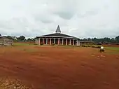 Photographie d'un monastère bas devant lequel est construite une église octogonale.