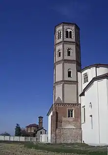 Photographie couleur d'un bâtiment dominé par un clocher, dont le plan carré passe à un octogone en montant.