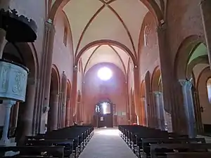 Nef d'église se terminant par une façade éclairée par une rosace.