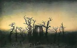 Pan de mur avec fenêtre en ogive, entouré d'arbres morts, dressé au milieu de pierres tombales