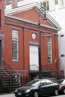 Bâtiment en brique rouge avec des portes blanches.