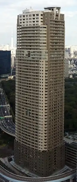 Aerial view of a brown and beige, rectangular, window-dotted high-rise