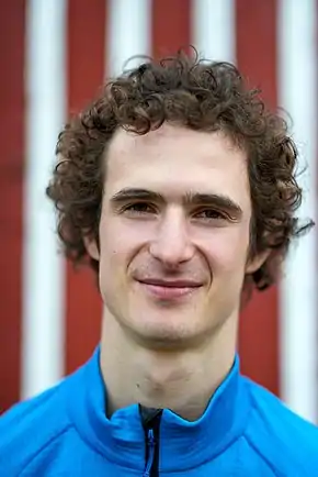 portrait d'un jeune homme blanc aux cheveux bruns bouclés