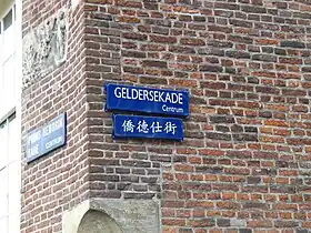 Panneau indiquant le nom du Geldersekade en néerlandais et en chinois.