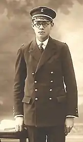 Jeune homme d'une vingtaine d'années en uniforme d'officier bleu sombre de la Marine française mais encore sans galon car seulement élève-officier