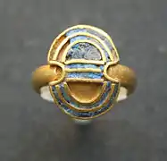 Bague en or en forme de double hache avec incrustations de lapis-lazuli