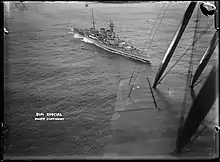 Photographie aérienne noir et blanc du HMS Hood en mouvement.
