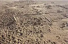 Photographie aérienne en couleurs de ruines dans le désert.