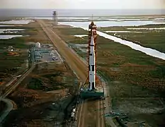 Photographie en couleur de la fusée Saturn V en déplacement vers son pas de tir.