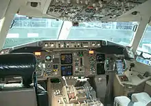 Photo d'un cockpit de 767-300ER montrant l'adoption d'un panneau d'instrumentation de nouvelle génération et de jauges et indicateurs analogiques.