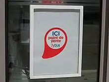 Photographie en couleurs d’une affiche sur une vitrine.