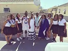 Une dizaine d'hommes et de femmes xhosas en costume traditionnel dans la rue.