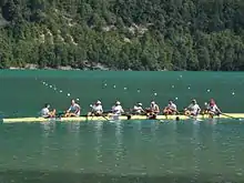 Neuf hommes se félicitent à l'arrivée de leur course dans leur bateau