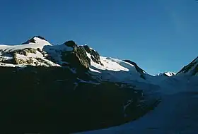 L'aiguille de la Bérangère et son glacier au soleil sur la gauche dominant le glacier de Tré-la-Tête dans l'ombre sur la droite de l'autre côté de la pointe des Conscrits.