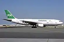 Avion circulant sur un tarmac avec un fuselage blanc et une queue vert foncé