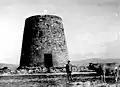 Un jeune garçon et une vache devant le moulin à vent d'Aixerrota, à Guecho.