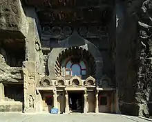 Entrée de chaitya lieu de pière, caverne 9. Une des plus anciennes, datée du IIe siècle. Façade à décor de kudu avec balcon. Bouddha (plus tardif) dans la pose de l'abhaya mudra, conférant l'absence de peur.