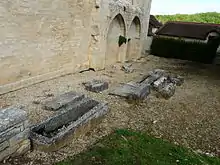 Sarcophage et pierres tombales, le long de la façade sud.