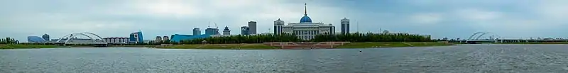 Vue panoramique sur le palais présidentiel Ak Orda (centre), la Salle de concerts centrale du Kazakhstan (gauche, bâtiment à droite de Tsesna Bank) et du Centre Nazarbayev (extrême gauche, bâtiment circulaire) sur les bords de l'Ichim.