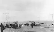 Des membres de l'équipage sur le pont d'envol de l'Akagi à Hitokappu Bay, dans les îles Kouriles en novembre 1941 avant l'attaque de Pearl Harbor. Les autres porte-avions en arrière-plan sont, de gauche à droite : Kaga, Shōkaku, Zuikaku, Hiryū, et Sōryū.