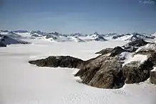 Un paysage neigeux avec des montagnes rocheuses.