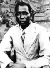 Photographie d'un Africain, nu-tête, en veste claire, avec cravate.