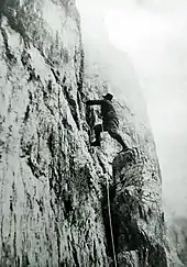 Le roi en tenue d'alpiniste escalade une paroi