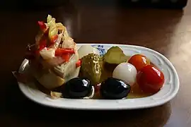 Alcachofa rellena con encurtidos y tomates cherry.