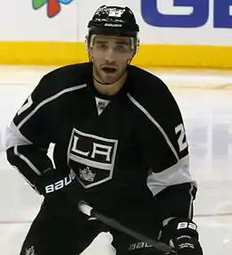 Photo d'un joueur de hockey sur glace avec un maillot noir frappé d'un blason comprenant les lettres LA et une couronne.