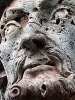 Gros plan sur le visage du prophète Jérémie, où l'on peut voir de nombreux trous dans la roche.