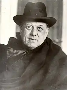 Portrait photographique en noir et blanc d'un homme âgé portant un chapeau et un costume noir