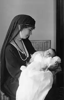 photographie en noir et blanc d'une femme voilée regardant un bébé qu'elle tient dans les bras.