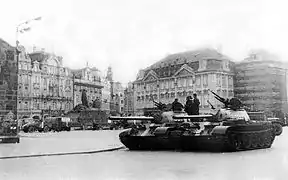 Deux chars d'assaut stationnés sur une place entourée d'immeubles historiques.