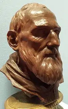 Sculpture de la tête d'un homme barbu.