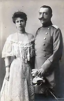 Photographie en noir et blanc d'un couple : la femme porte une robe claire et une tiare ; l'homme un uniforme de l'armée allemande.
