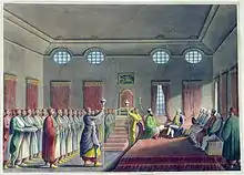 gravure colorisée : réception officielle à gauche des serviteurs en rangs ; à droite des hommes assis sur des divans